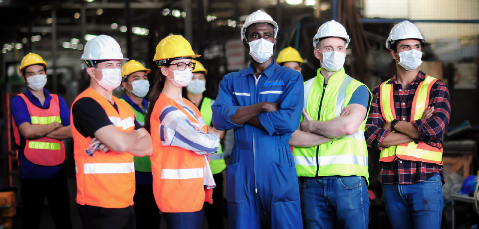 Diverse Workers Standing in Group on Site with Arms Folded